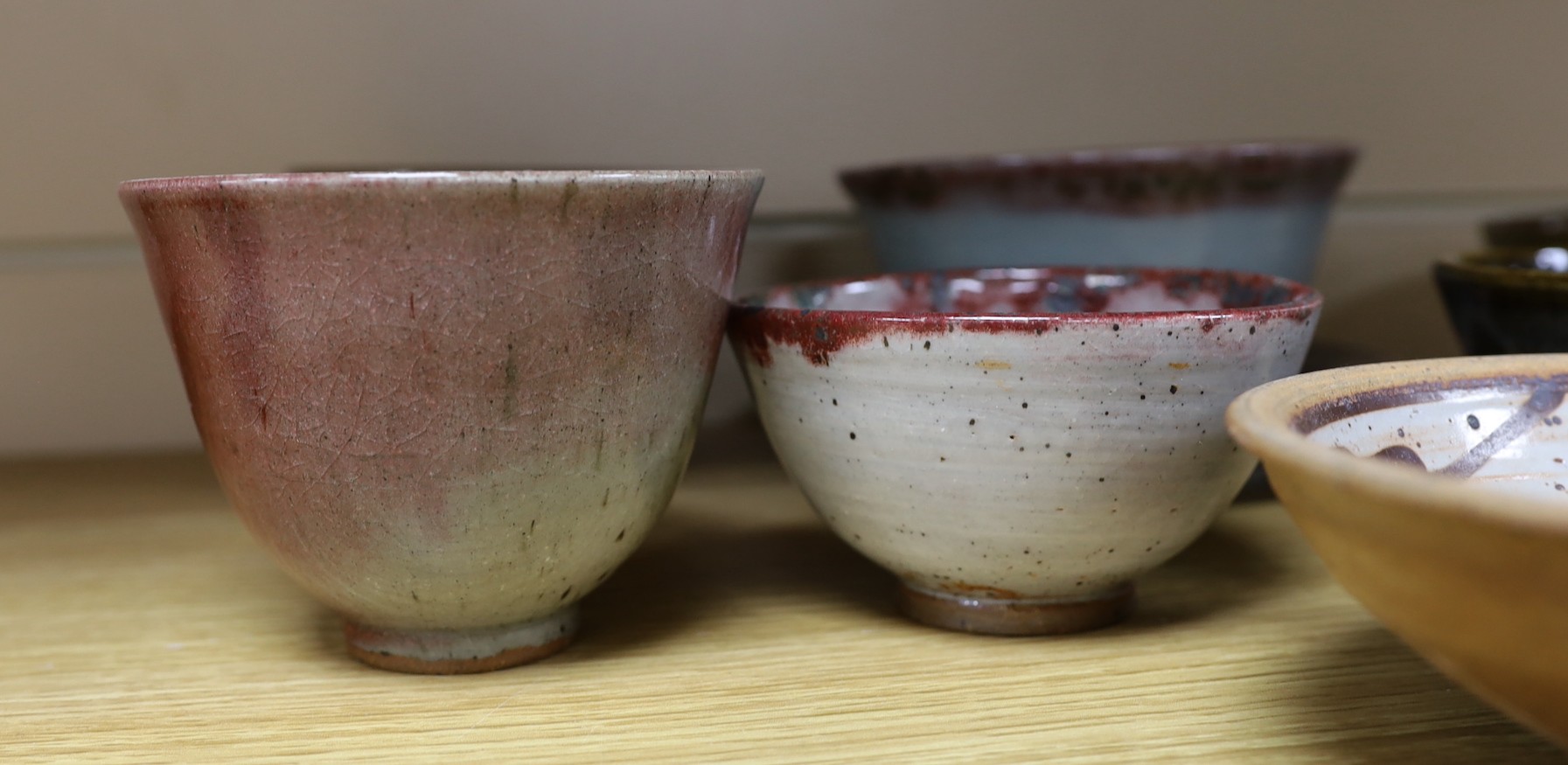 A large pottery figural tile together with a collection of studio pottery bowls